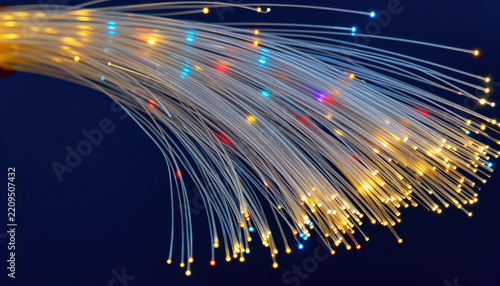Optical fiber light trail glowing strand abstract background blue background yellow light data transmission communication network technology concept digital connection