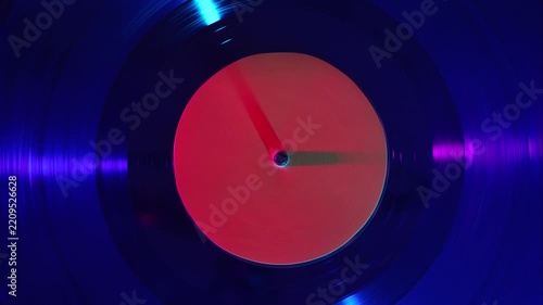 Vinyl record spinning under colorful light