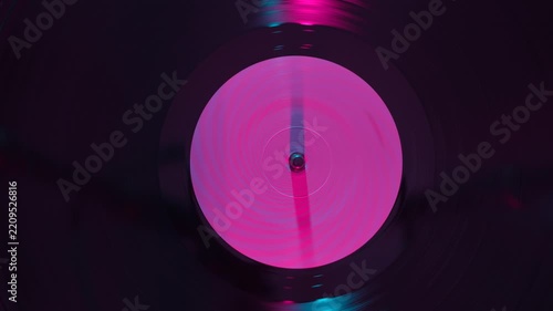 Close up of vinyl record under colorful light