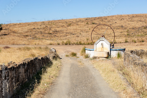 Traditional water fountain and old well in a dry rural landscape, Alentejo, Portugal