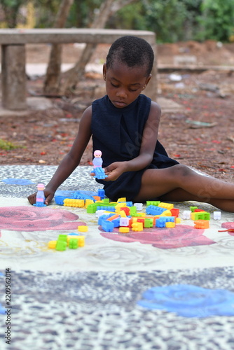 Little girl on the floor at home playing with building bricks