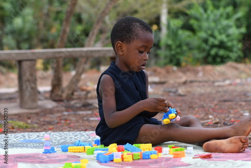 Little girl on the floor at home playing with building bricks