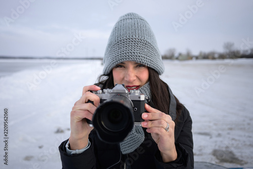 Woman with camera at Sylvan Lake in winter