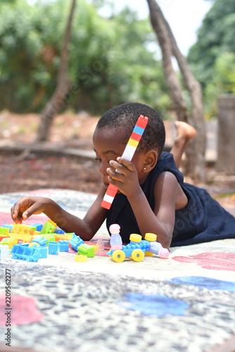 Little girl on the floor at home playing with building bricks