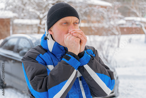 Man warm hands during winter chore in snowy yard