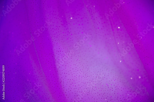 A delicate dark background. A screen saver with fabric. A festive decoration. Light and bokeh. Purple and blue colors. A greeting card for a wedding, engagement, or March 8. A template and copy space.