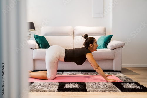 Woman practice yoga at home in a bright living room
