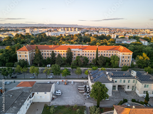 Zadar, Croatia - 17 May 2025: Aerial view of Vladimir Nazor Grammar School surrounded by lush trees and urban buildings in the historic city of Zadar.