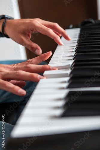 Hands play piano keys in close-up musical performance