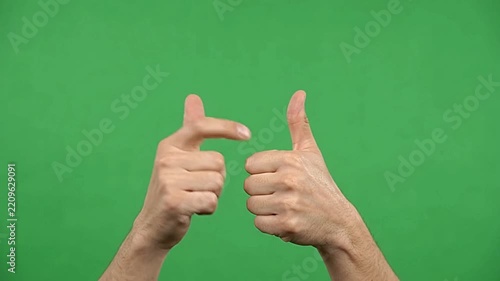 Two male hands showing a thumbs-up gesture with positive sign on green screen background video footage