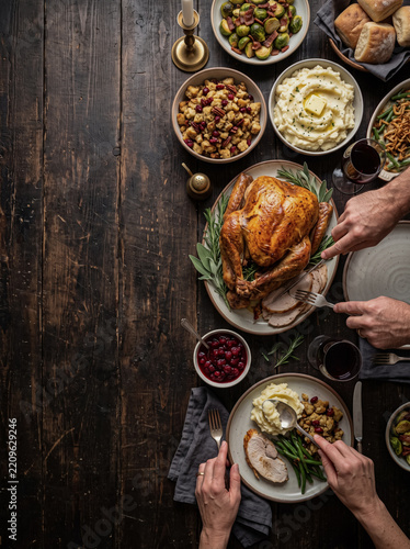 Top view of people dining roasted turkey at rustic thanksgiving table