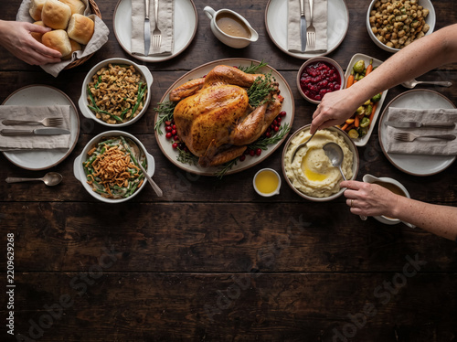 Top view of people dining roasted turkey at rustic thanksgiving table
