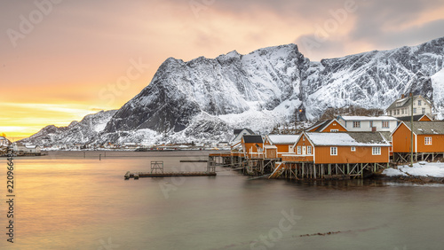 Yellow wooden fishing village in last sunlight in arctic fjord