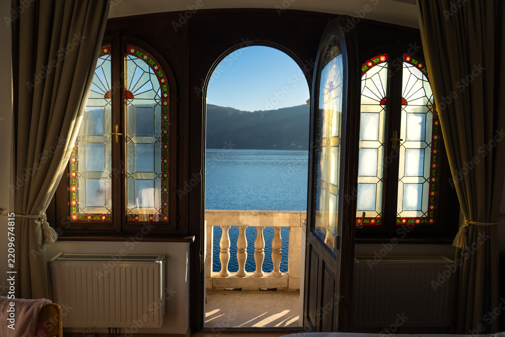 Fototapeta premium Lake View Through Open Door and Stained Glass Windows in Austria