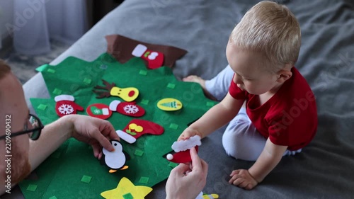 Father and his son decorating toy Christmas tree together. Educational games for children. 4K