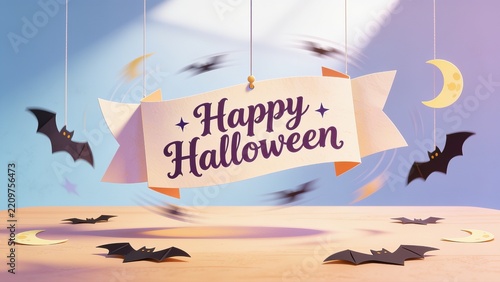 Hanging cream ribbon banner reading Happy Halloween in purple text on light wood tabletop
