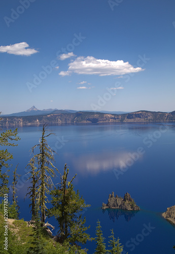 Crater Lake National Park with blue water and Phantom Ship island rock formation under a bright clear summer sunny sky - Oregon, United States