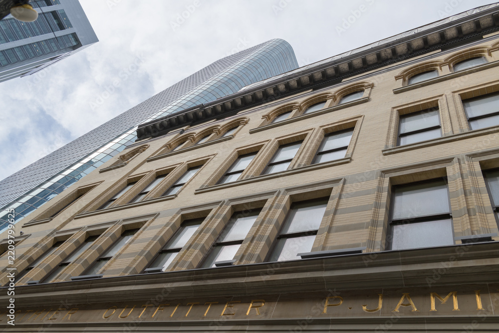 Obraz premium exterior of heavily restored Philip Jamieson Building (later known as FW Woolworth store) at 2 Queen St W and Cadillac Fairview office tower, Toronto