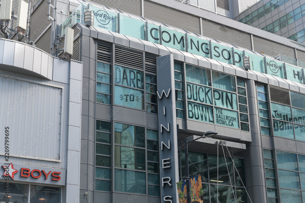 Obraz premium exterior of The Tenor with Ballroom Bowl, coming soon signage of Hard Rock Cafe and Winners, a department store, and other signage, outside Yonge St side of 10 Dundas St E, Toronto