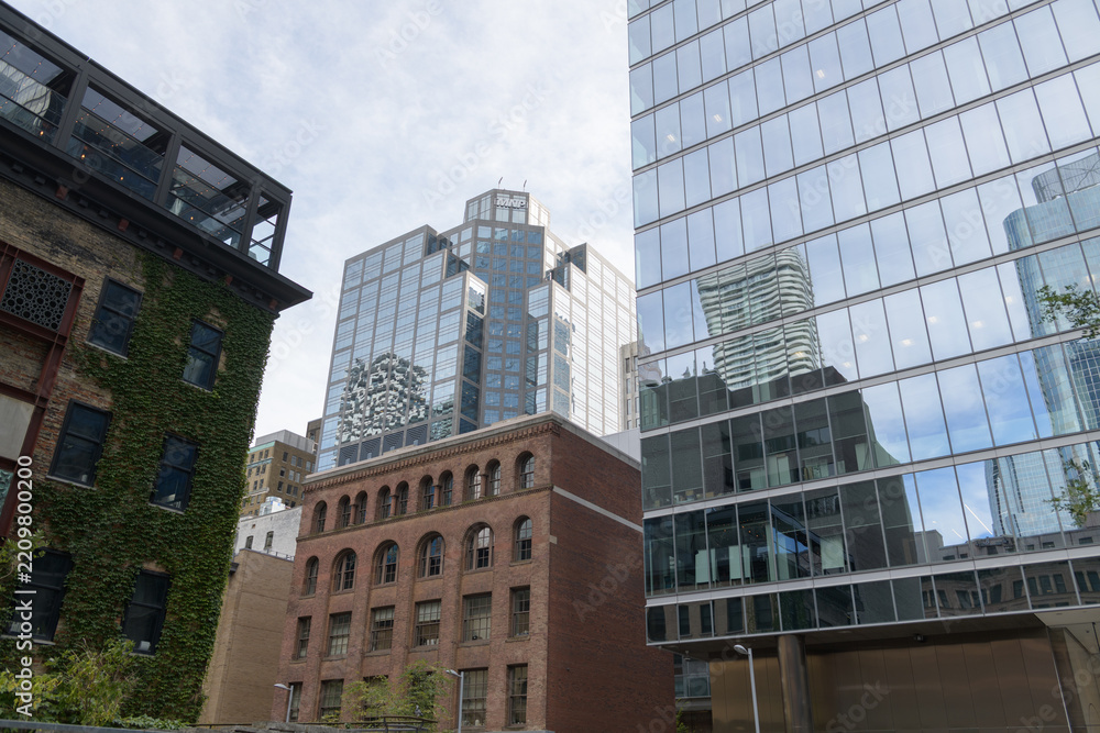 Obraz premium looking southeast from outside Cloud Gardens park to historic brick building (Comet Bicycle Co/Aikenhead's Hardware, 1905) with Bay Adelaide Centre East Tower, Toronto