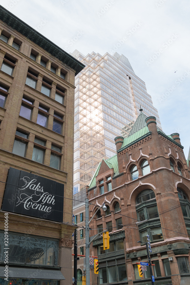 Fototapeta premium historic and modern architecture in Toronto: Confederation Life Building (1892), Simpson Department Store (1895) & One Queen Street East, a business center
