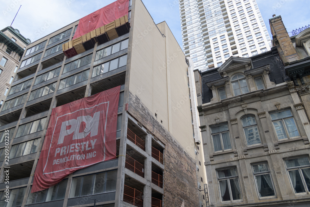 Obraz premium old office building being partly demolished at 55 Yonge St and facade of historic Contor House and contrast with 88 Scott Street/20 Wellington Street East, an office and residential tower, Toronto