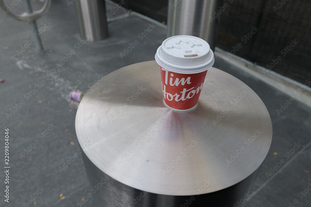 Fototapeta premium Tim Hortons beverage cup on a wide stainless steel bollard in Toronto