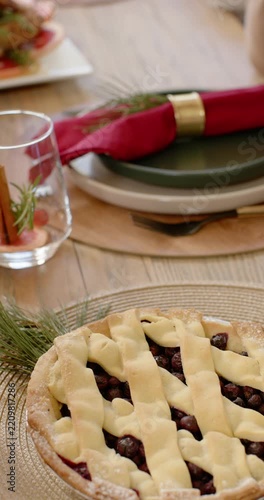 Vertical video: Camera is pulling back, revealing lattice pie and roasted bird on table for feast