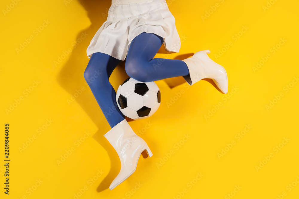 Obraz premium Sports fashion and youth culture, woman in white skirt and blue tights playing with a soccer ball on a bright yellow background for creative advertising