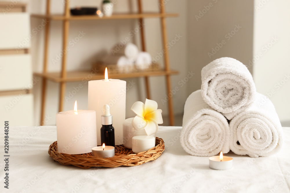 Fototapeta premium Wellness and spa relaxation, candles with essential oil and rolled towels on massage table for holistic health and beauty treatment in therapy room