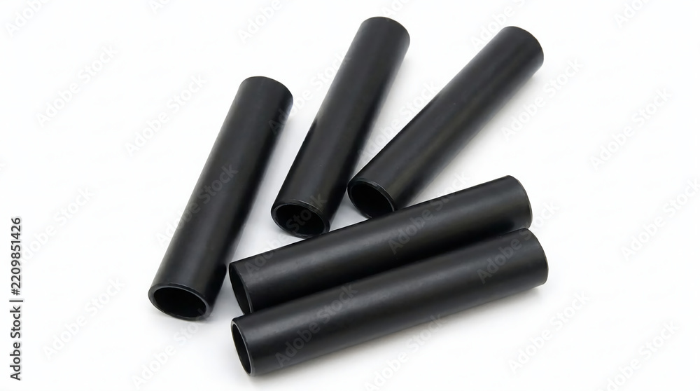 Fototapeta premium Several black cylindrical tubes arranged on a white background, suggesting industrial or scientific applications