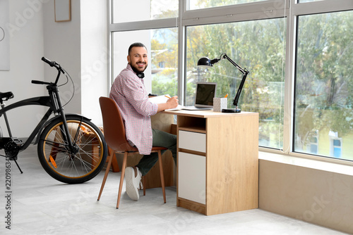 Remote work and digital nomad lifestyle, man working on laptop at home office...