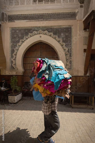 Man carrying the bunch of colored furs from the tannery in Fes old town Morocco