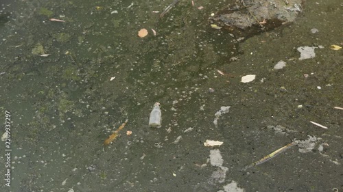 Polluted shallow river with sediment and wastewater discharge, symbolizing human impact, environmental destruction, ecosystem degradation, water contamination.