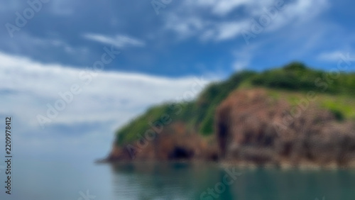 Softly defocused island silhouettes float above a tranquil azure sea and sky, creating a dreamy minimalist background ideal for desktop and design.