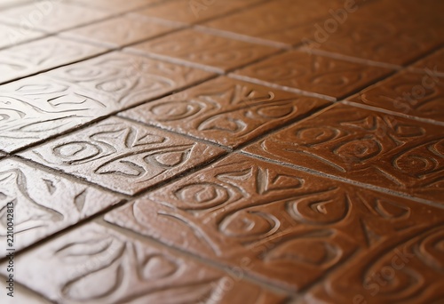 A close-up of patterned encaustic floor tiles, soft natural light