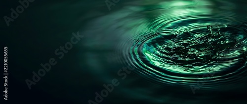 Abstract dark green water ripples background with circular concentric wave patterns on liquid surface.