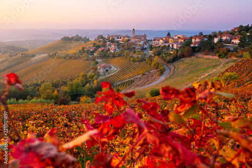 sunset view of Treiso village surrounded by colorful autumn vineyards in Langhe region, Piedmont, Italy