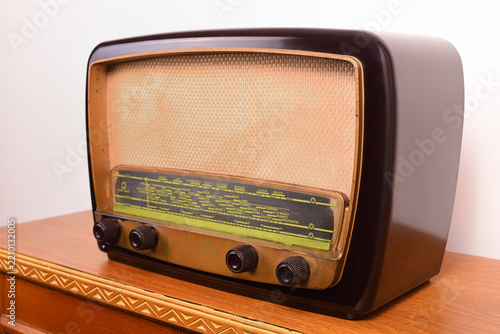 Vintage radio on a rustic brown wooden antique dresser. Authentic vintage objects and nostalgia concept.