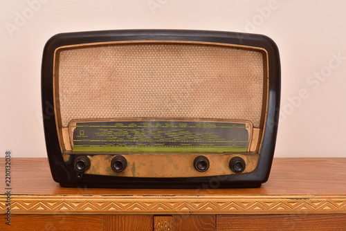 Vintage radio on a rustic brown wooden antique dresser. Authentic vintage objects and nostalgia concept.