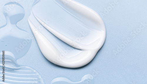samples of cosmetic care products smear of cream and gel texture on a light blue background