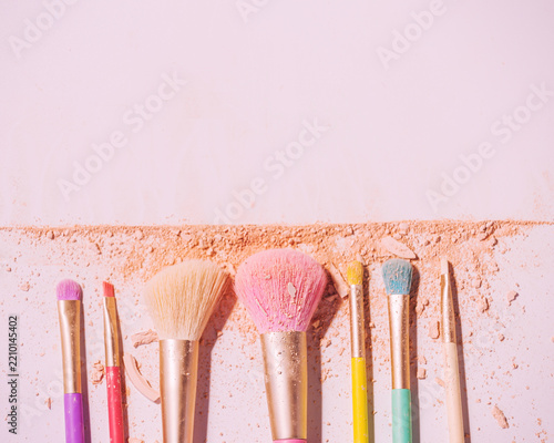 Make up brushes with powder on white background