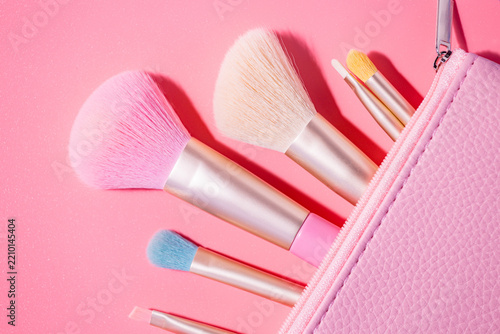 Make up brushes with powder on pink background