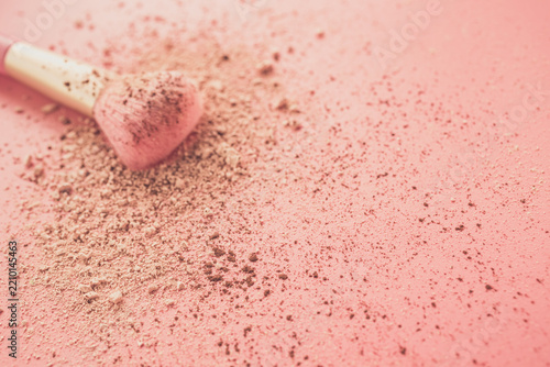 Make up brushes with powder on pink background