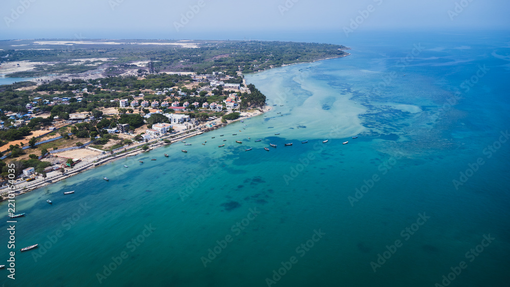 Fototapeta premium Aerial drone view of the Rameswaram coastline in Tamil Nadu, India, featuring turquoise coastal waters, sandy shoreline, fishing boats, and the vibrant island town.