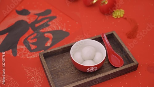 Festive Chinese Glutinous Rice Balls in Red Bowl on Wooden Tray with Red Spoon