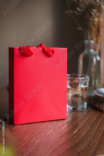Red gift bag on a wooden table in a restaurant for a celebration