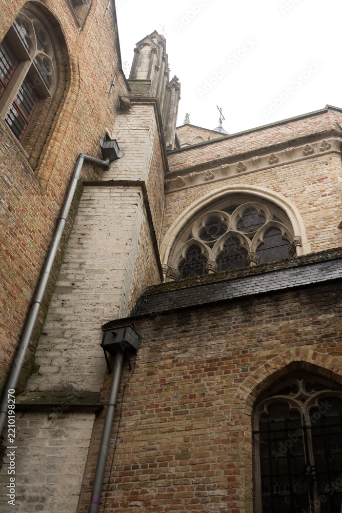 Obraz premium Ancient stone Bonifacius Bridge and historic brick house over canal in Bruges, Belgium