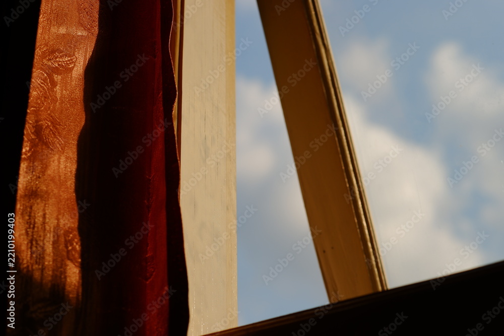 Fototapeta premium Open window frame with curtain and blue sky view