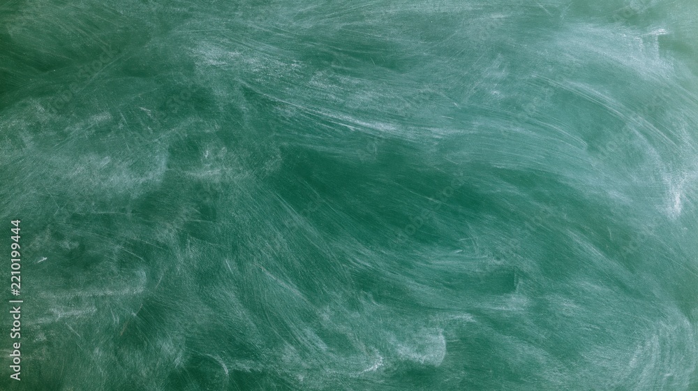 Obraz premium Green chalkboard surface with erased white chalk marks filling the frame